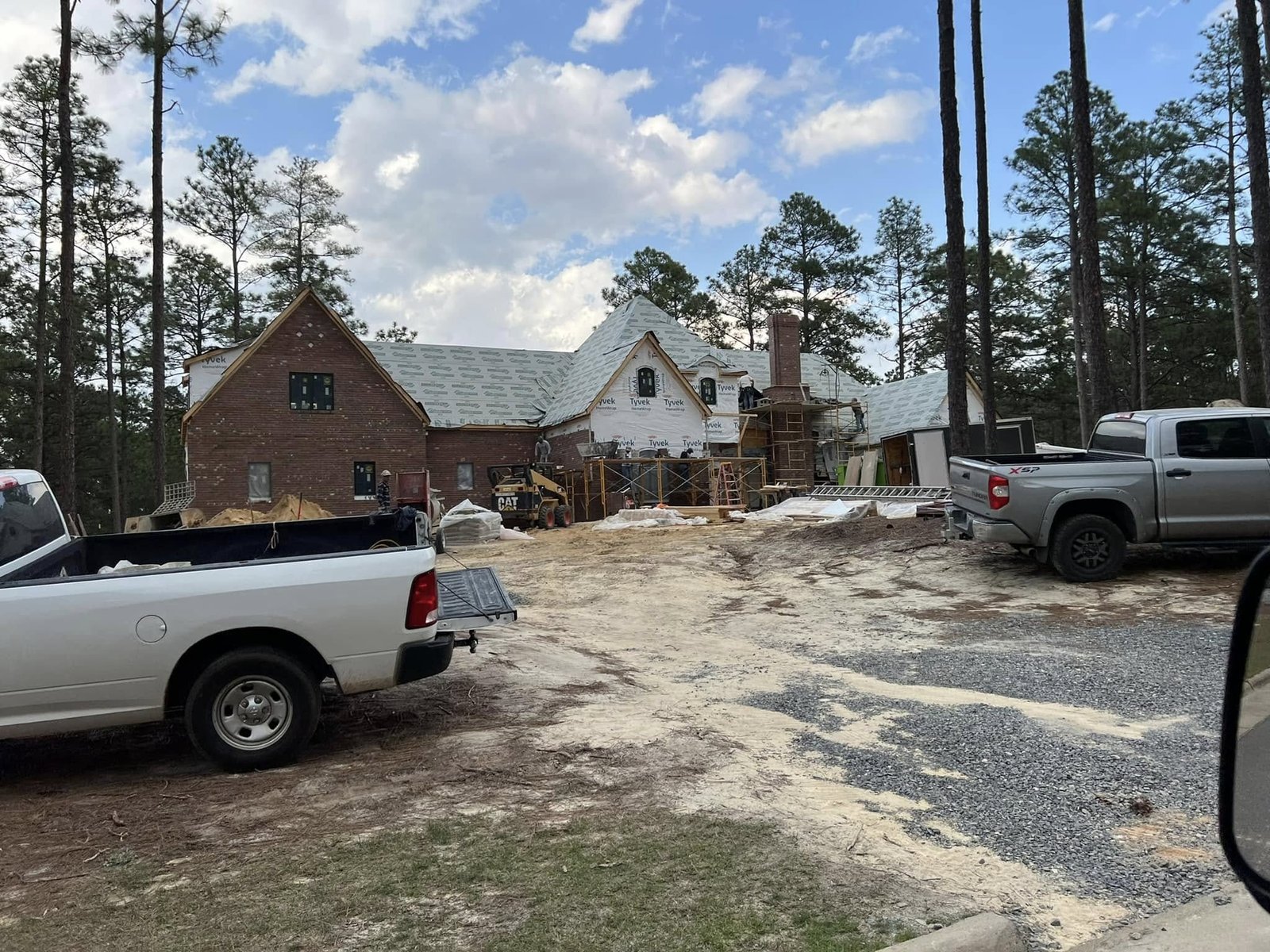 Large brick home under construction, framing stage